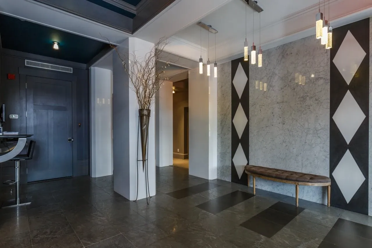 A residential corridor with patterned walls and pendant lighting