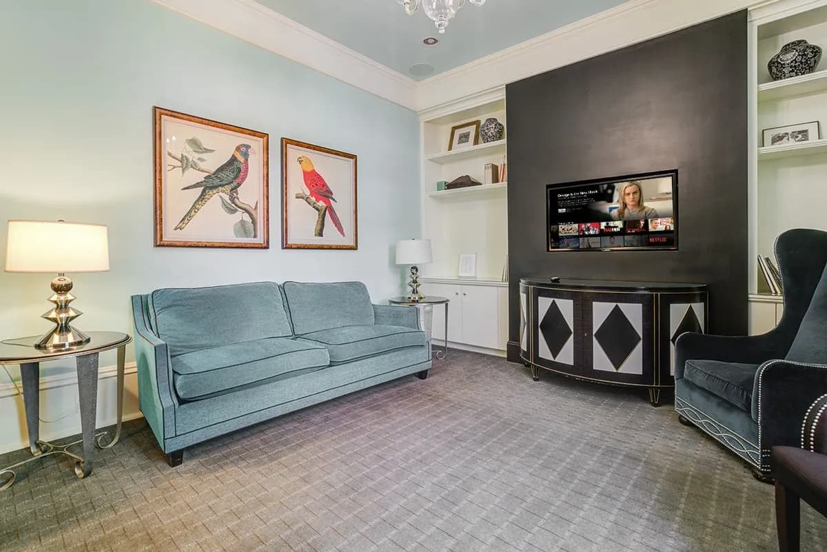 The lounge television corner with a sofa, armchairs and framed prints