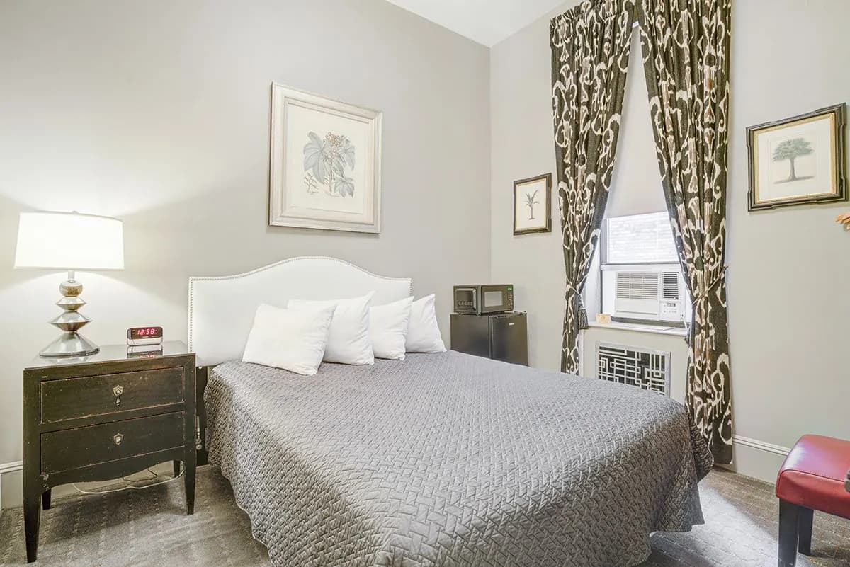 A Studio Basic with a queen bed, patterned curtains and framed artwork