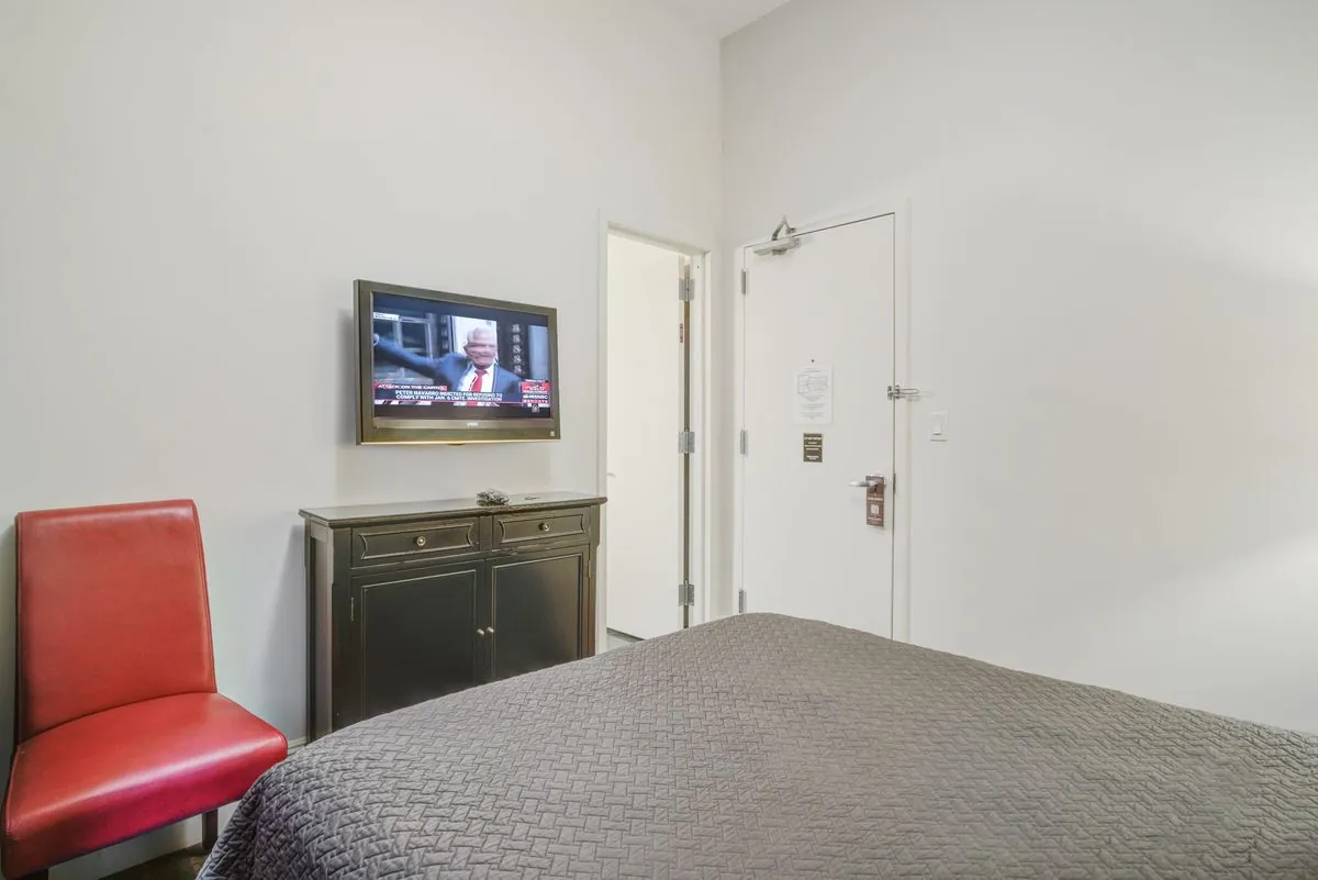 A Studio Basic looking toward the door, dresser and television
