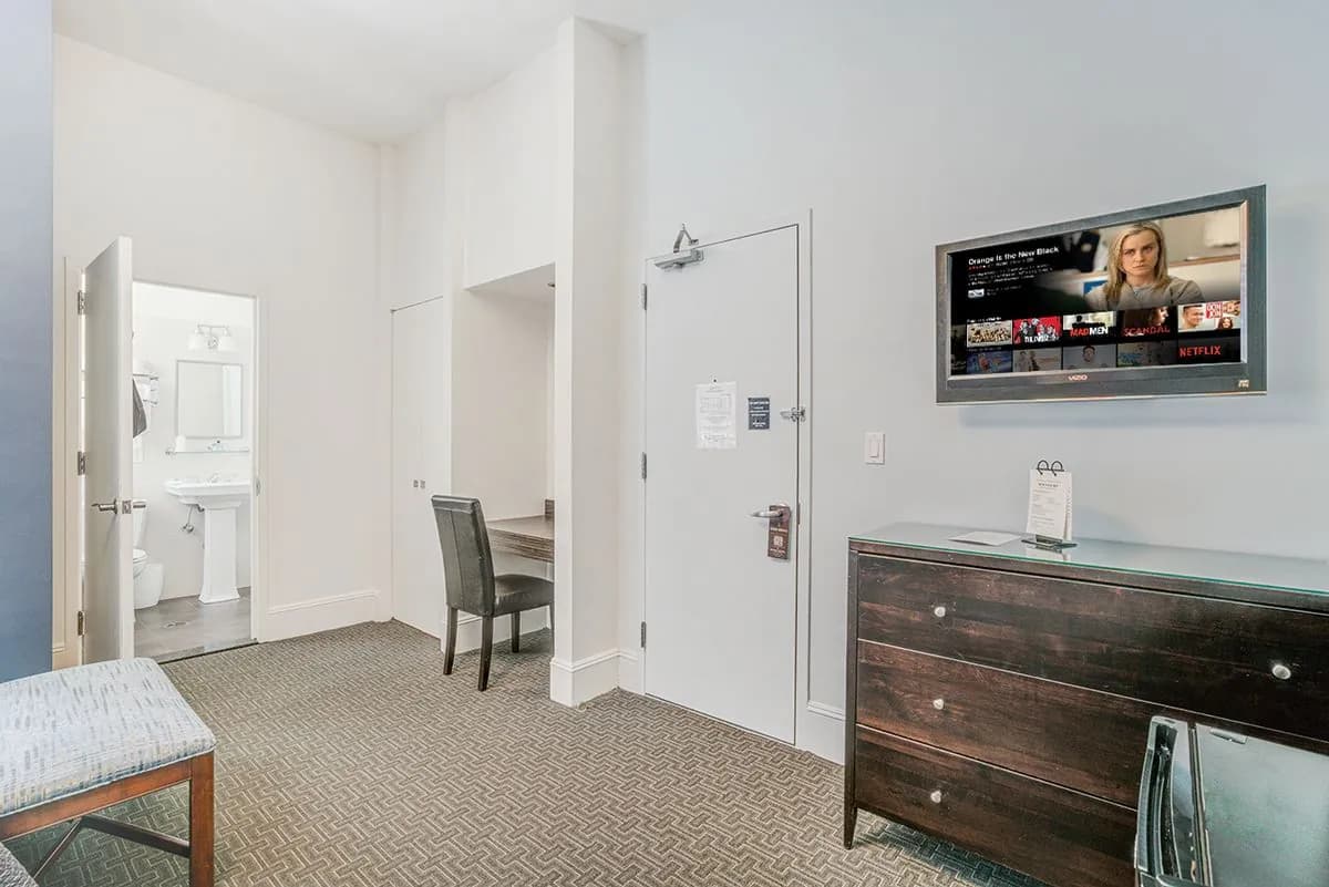 A Studio Basic with the en-suite bathroom door open beside the dresser